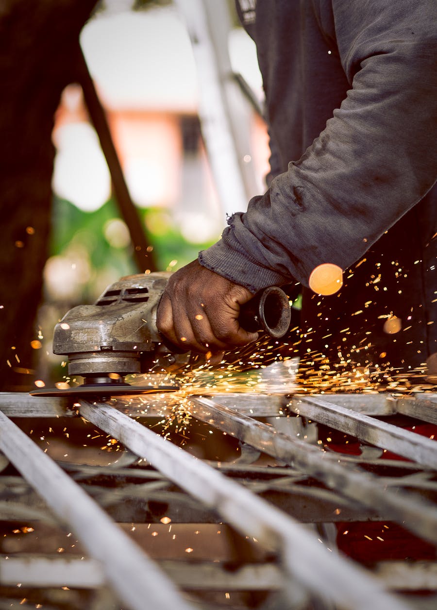Trabajador industrial esmerilando metal con chispas