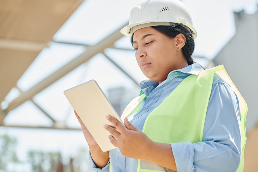 Ingeniera con casco usando una tablet en terreno